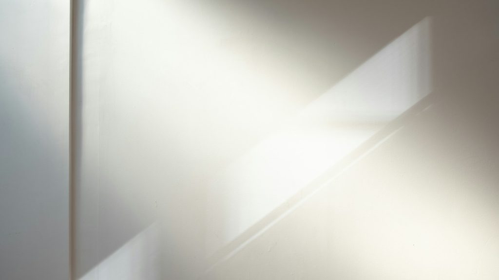 Soft daylight forms layered shadows across a pale wall